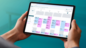 Foto eines Tablets mit geöffnetem thevea-Wochenkalender, der farblich nach Mitarbeitern getrennte Patiententermine für eine gesamte Praxiswoche anzeigt.